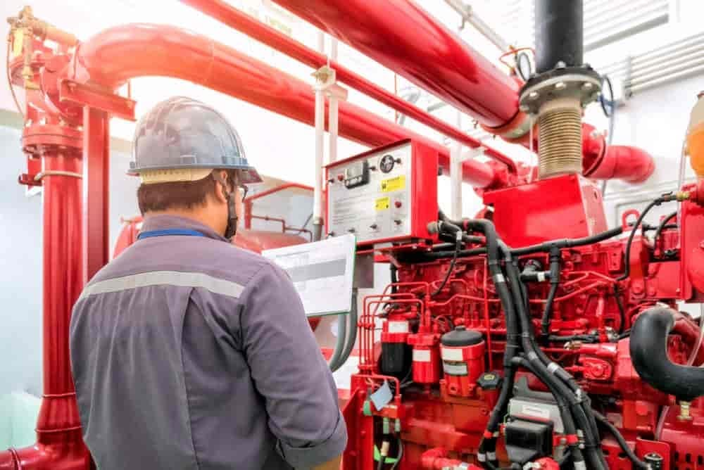 Técnico Tesla verificando painel de bomba de incêndio